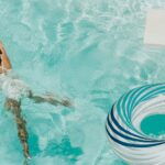 girl wearing swimsuit and swims in swimming pool